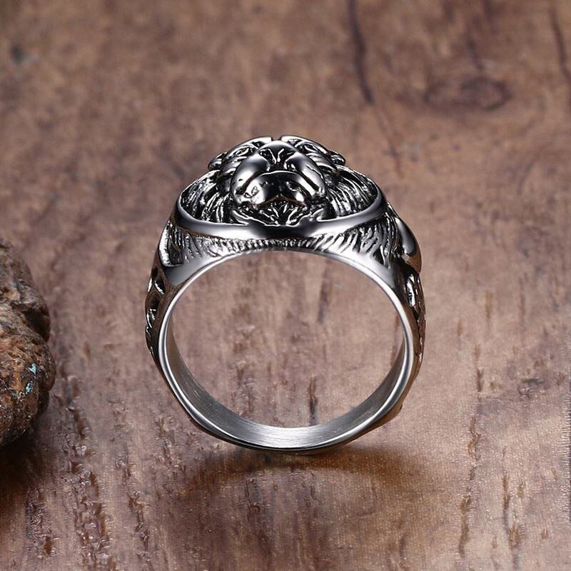 Silver lion head ring on a wooden surface