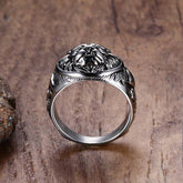 Silver lion head ring on a wooden surface