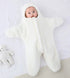 Baby wrapped in a white blanket on a light gray background