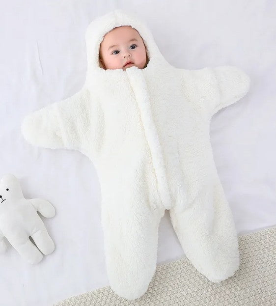 Baby wrapped in a white blanket on a light gray background