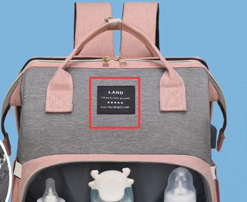 Gray backpack with pink straps and a visible brand label on a blue background