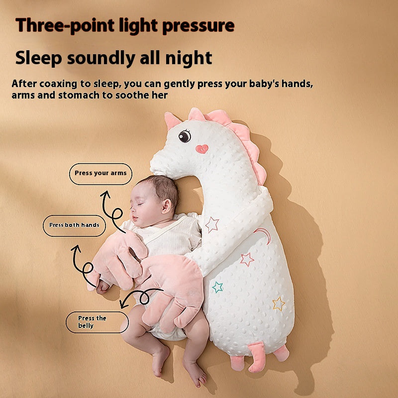 Baby sleeping on a dinosaur-shaped comfort pillow with instructions on how to use it.