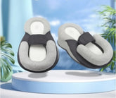 Pair of gray and black slippers on a blue platform with a blurred natural background