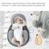 Baby lying in a gray and white baby nest with text about its design and safety features.