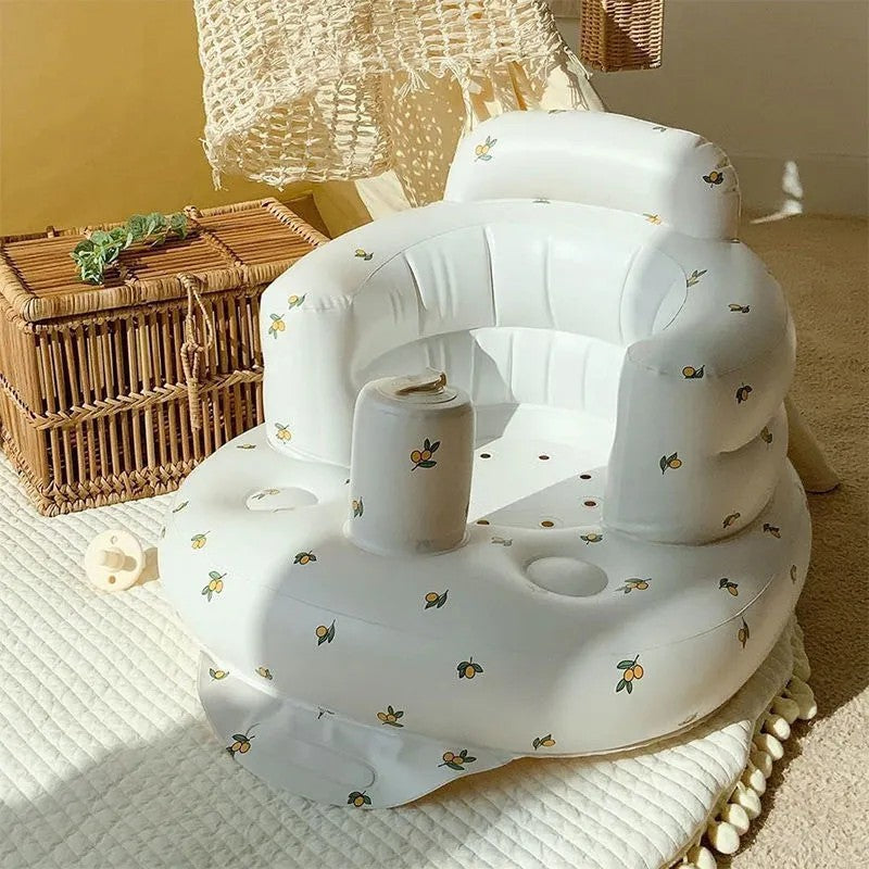 White inflatable baby seat with floral patterns on a textured surface.