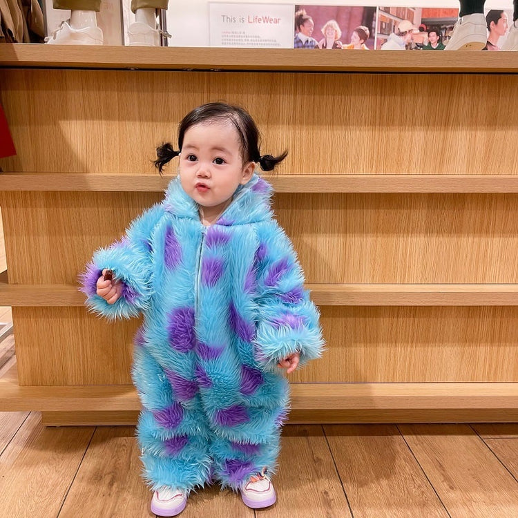 Child wearing a blue and purple fluffy outfit standing in front of wooden shelves.