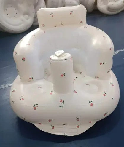 White inflatable baby seat with floral pattern on a blue surface