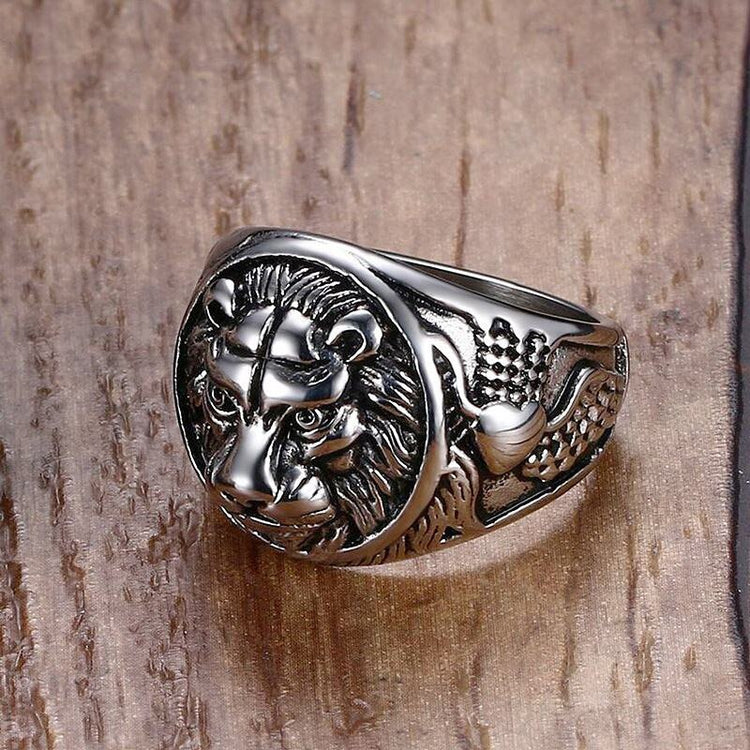 Silver lion head ring on a wooden surface